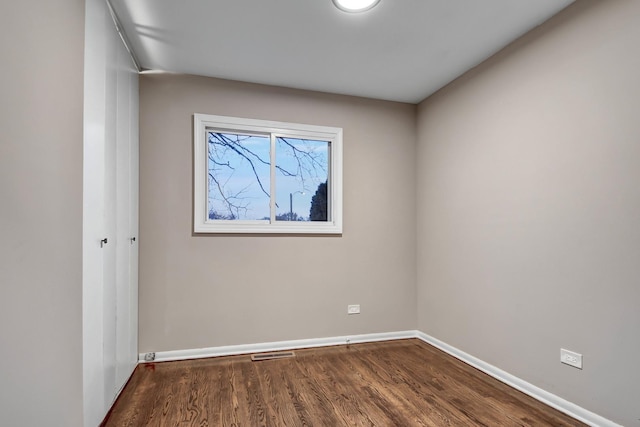 spare room featuring dark wood-type flooring