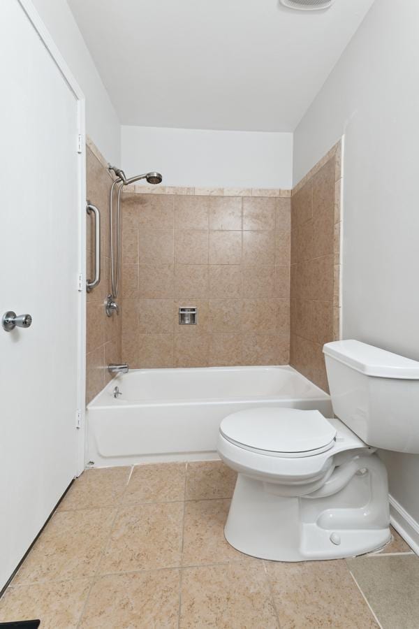 bathroom with toilet and tiled shower / bath combo