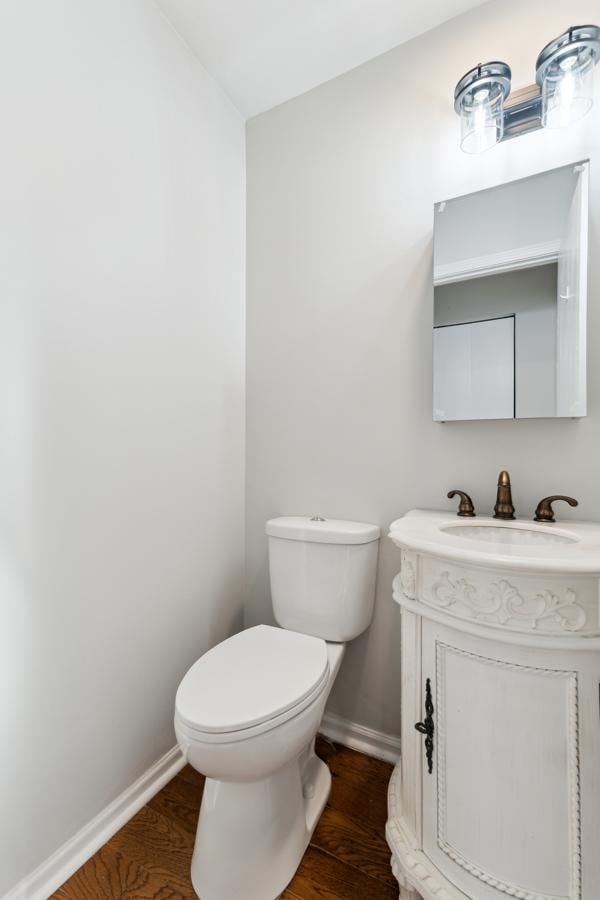 bathroom featuring vanity, hardwood / wood-style floors, and toilet