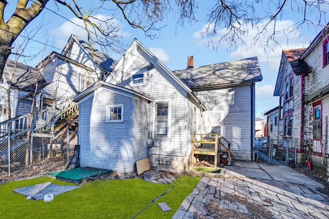 back of house featuring a lawn and a patio