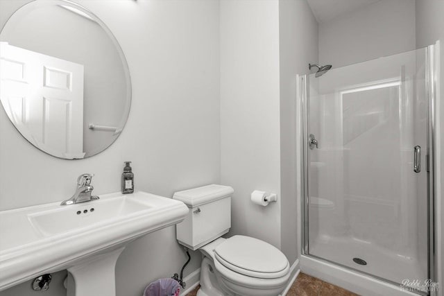 bathroom featuring sink, an enclosed shower, and toilet