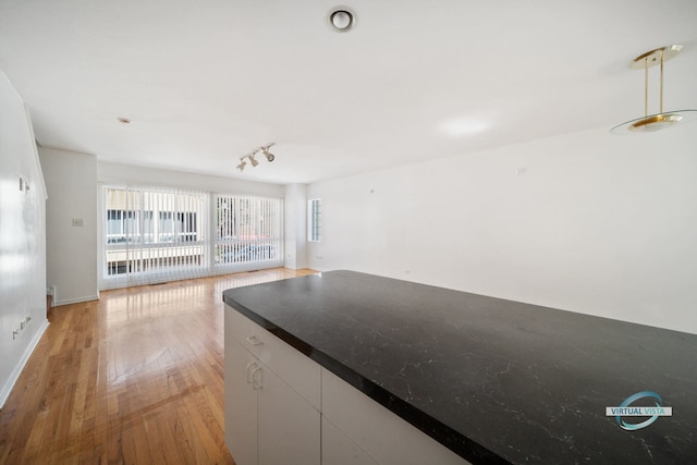 kitchen with pendant lighting, white cabinets, and light wood-type flooring