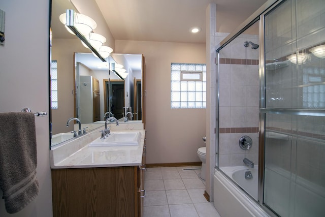 full bathroom with toilet, tile patterned floors, vanity, and bath / shower combo with glass door