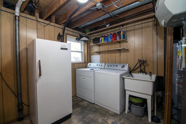 washroom with gas water heater, wooden walls, and washer and clothes dryer