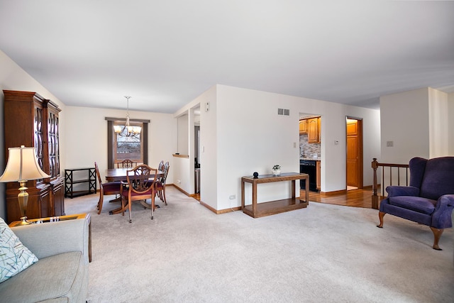 living room with light carpet and a notable chandelier