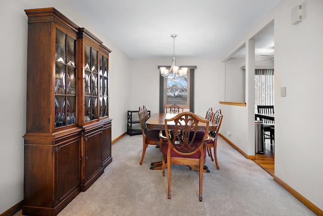 carpeted dining area featuring an inviting chandelier