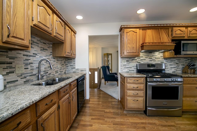 kitchen with stainless steel appliances, premium range hood, sink, and dark hardwood / wood-style flooring