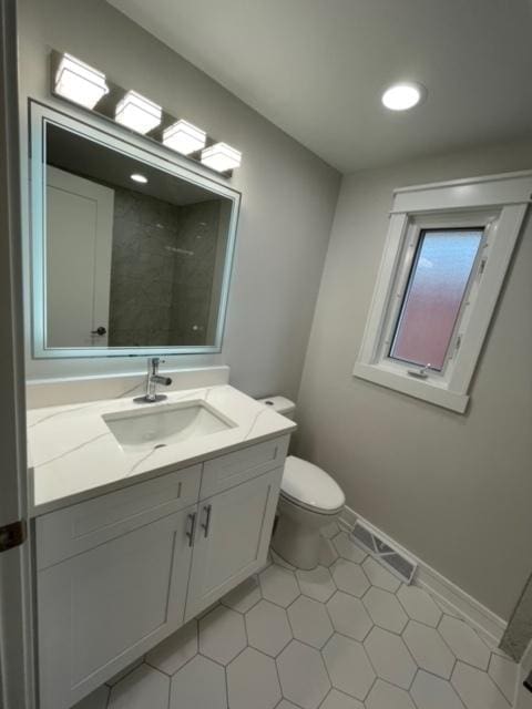 bathroom with vanity, a shower, and toilet