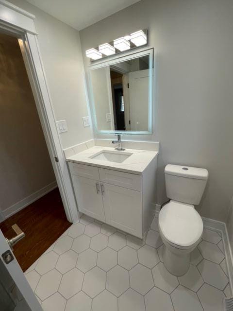 bathroom featuring vanity, tile patterned flooring, and toilet