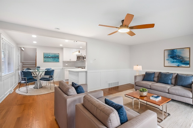 living room with ceiling fan and light wood-type flooring