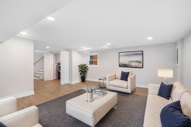 living room featuring wood-type flooring and washer / dryer