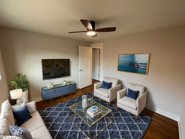 living room featuring ceiling fan and dark hardwood / wood-style flooring