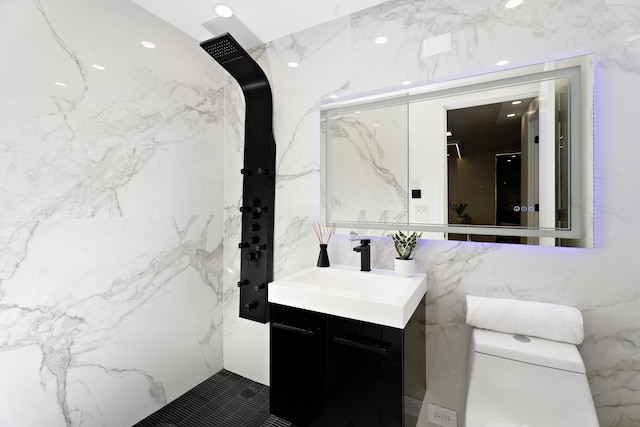 bathroom featuring tile walls, vanity, and toilet