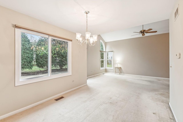 carpeted empty room featuring lofted ceiling and ceiling fan with notable chandelier