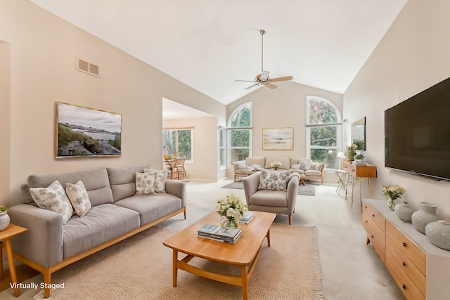 living room with ceiling fan, high vaulted ceiling, and light carpet