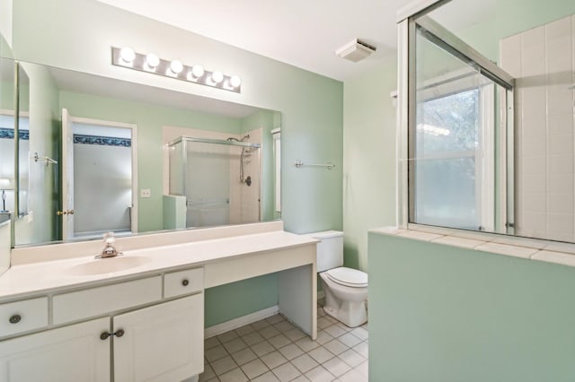 bathroom with vanity, tile patterned floors, a shower with door, and toilet