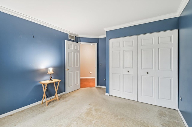 unfurnished bedroom with crown molding, light colored carpet, and a closet