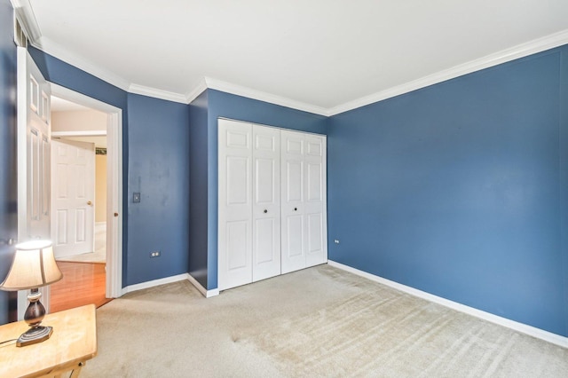 unfurnished bedroom with crown molding, carpet, and a closet