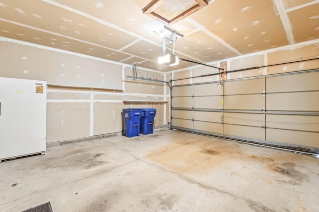 garage with a garage door opener and white fridge