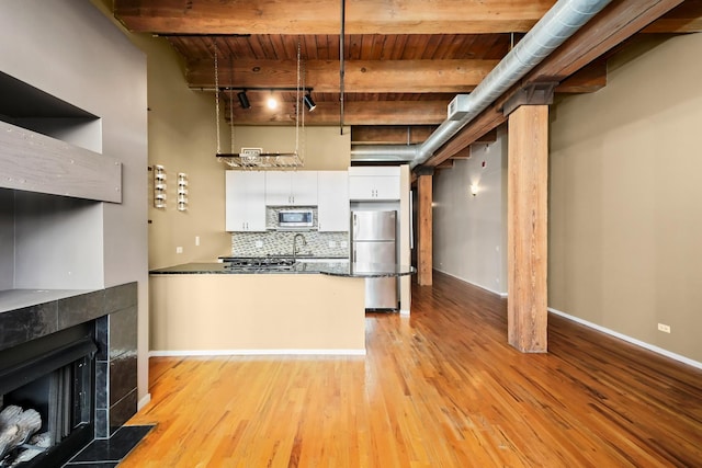 kitchen with pendant lighting, backsplash, stainless steel appliances, white cabinets, and wooden ceiling