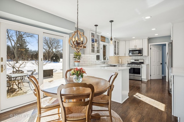 dining area featuring a notable chandelier, dark wood-type flooring, and recessed lighting