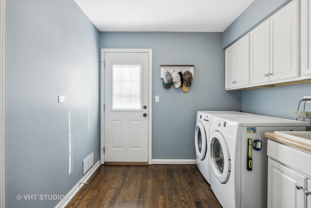 washroom featuring cabinet space, baseboards, visible vents, dark wood finished floors, and independent washer and dryer