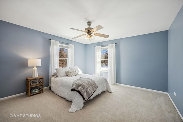 carpeted bedroom with ceiling fan and baseboards