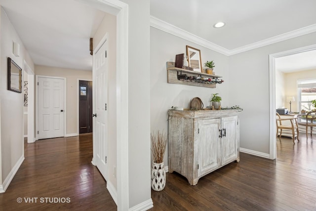 hallway with dark wood-style floors, recessed lighting, ornamental molding, and baseboards