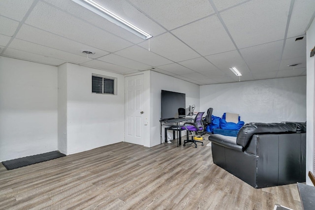 living room featuring a drop ceiling and hardwood / wood-style floors