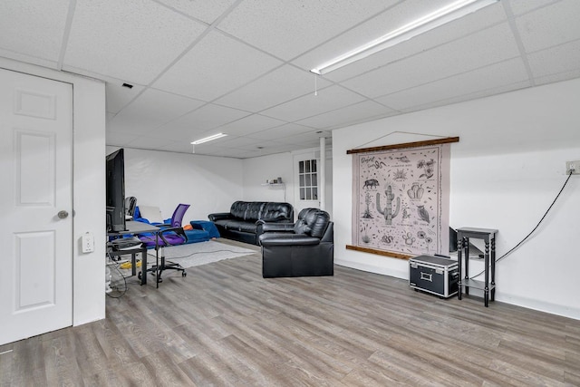 living room with hardwood / wood-style flooring and a paneled ceiling