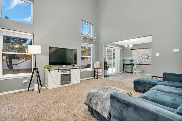 carpeted living room with a high ceiling and a notable chandelier