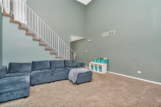 carpeted living room featuring a high ceiling