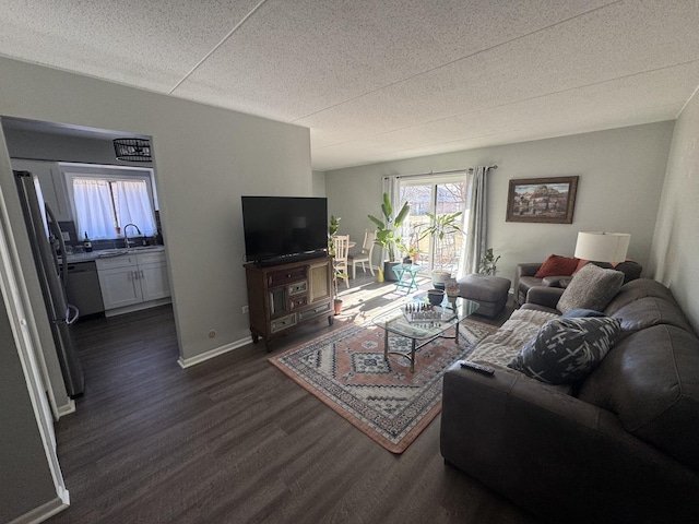 living room featuring sink, dark wood-type flooring, and a textured ceiling