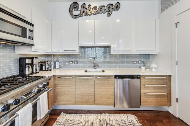 kitchen featuring stainless steel appliances, white cabinets, and backsplash