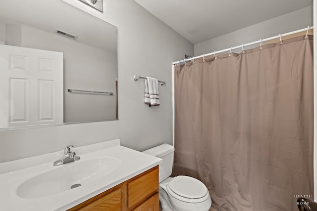 bathroom featuring walk in shower, vanity, and toilet