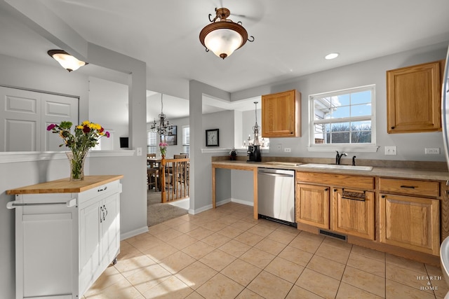 kitchen featuring a wealth of natural light, dishwasher, sink, and light tile patterned floors