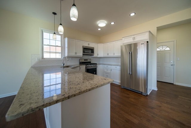 kitchen with white cabinetry, sink, kitchen peninsula, and appliances with stainless steel finishes