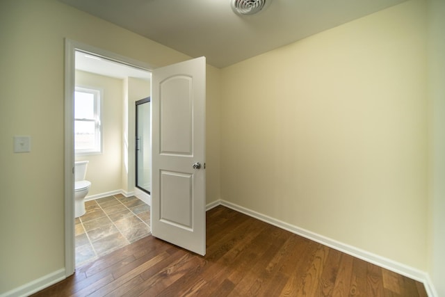 interior space with wood-type flooring and toilet