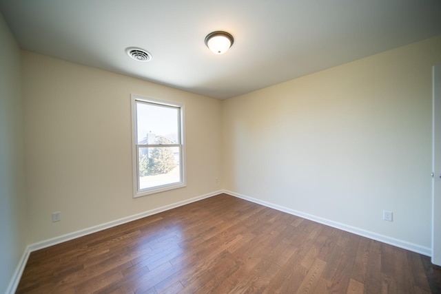 spare room with dark hardwood / wood-style floors