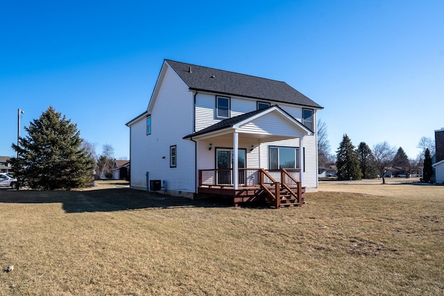 rear view of house with central AC and a lawn