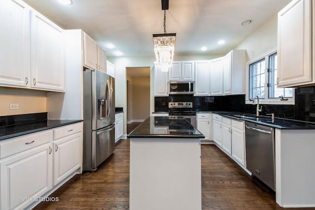 kitchen with a kitchen island, white cabinetry, sink, hanging light fixtures, and stainless steel appliances