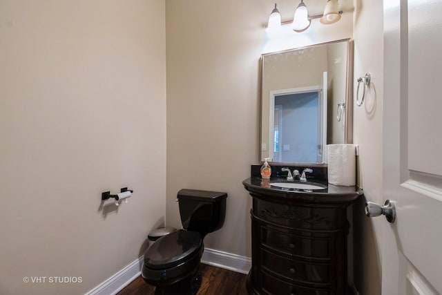 bathroom featuring vanity, wood-type flooring, and toilet