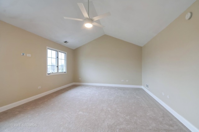 carpeted spare room featuring vaulted ceiling and ceiling fan