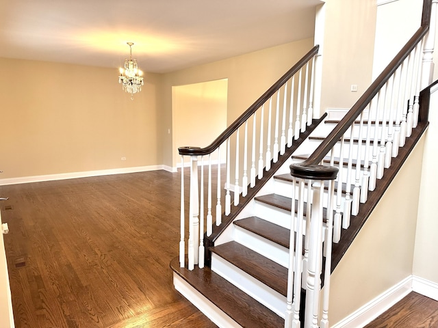 staircase featuring a chandelier and hardwood / wood-style floors