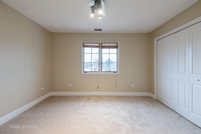 unfurnished bedroom with light carpet and a closet