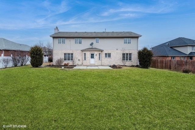 back of property with a yard and a patio