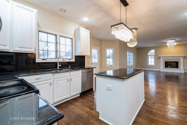 kitchen with sink, decorative light fixtures, stainless steel dishwasher, a kitchen island, and white cabinets