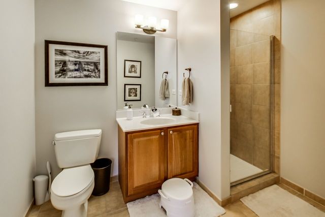 bathroom featuring vanity, an enclosed shower, tile patterned floors, and toilet