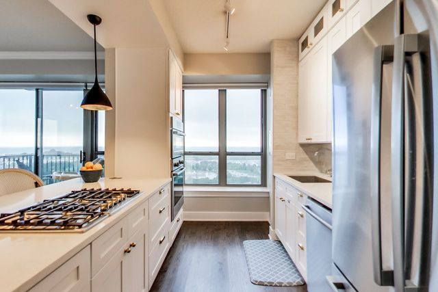 kitchen with sink, white cabinetry, decorative light fixtures, appliances with stainless steel finishes, and decorative backsplash