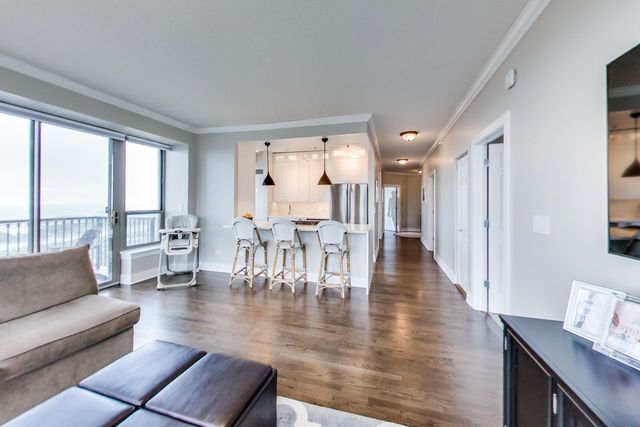 living room with crown molding and dark wood-type flooring